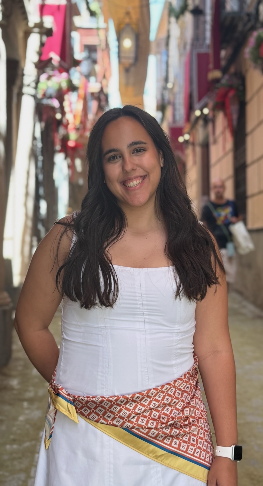 Retrato de Beatriz sonriendo en una calle decorada